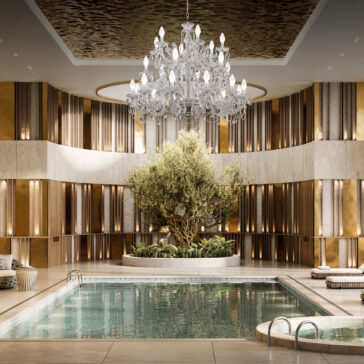 A luxurious indoor swimming pool features gold-accented walls and a tall olive tree centerpiece. The space exudes elegance with a Large Outdoor Cut Crystal Chandelier hanging from the metallic ceiling, creating an opulent oasis-like atmosphere.