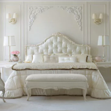 Luxurious Classic Italian Designer Button Upholstered Bed A luxurious bedroom centers around the Luxurious Classic Italian Designer Button Upholstered Bed, showcasing a stunning tufted headboard with intricate detailing that exudes classic Italian elegance. The bed is adorned with plush pillows and a satin bedspread. At the foot of the bed sits a matching bench. Completing the room are elegant wall sconces and a pair of table lamps placed on bedside tables.