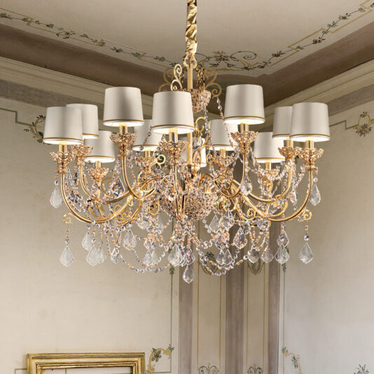 A High End Gold Plated Crystal Pendant Chandelier, featuring intricate detailing, hangs from the ceiling. It showcases multiple candle-like light fixtures adorned with white shades, and is embellished with an abundance of crystal ornaments that add sparkle and elegance to the room.