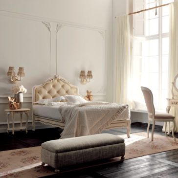 Italian Rose Detail Luxury Single Bed A bright, elegant bedroom showcases the Italian Rose Detail Luxury Single Bed with its plush, tufted headboard and neatly made cream-colored quilt adorned with delicate Italian rose details. The vintage-style decor includes a matching nightstand, a vanity with a mirror, and a cushioned bench. Large windows with sheer curtains let natural light flood the room.