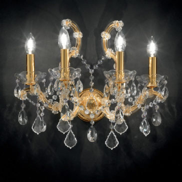 A lavish 4 Light Venetian Wall Light, gold-plated and featuring candle-shaped bulbs adorned with clear, teardrop-shaped crystal pendants and intricate crystal details, creates a stunning contrast when mounted on a dark background.