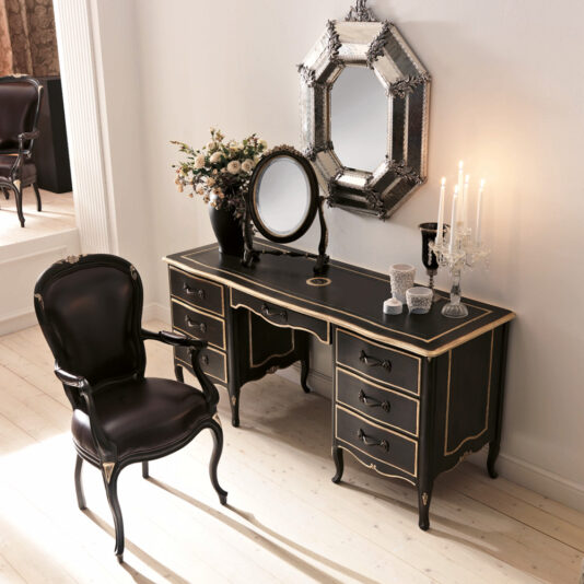 The Luxurious Italian Desk set includes an elegant black and gold-trimmed desk with multiple drawers, complemented by a matching chair. The desk is beautifully adorned with a floral arrangement, a decorative mirror, and candelabras. An octagonal wall mirror hangs above the desk for added sophistication.