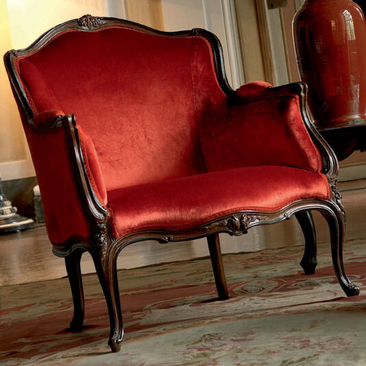 A Venetian Style Walnut Italian Armchair, adorned with red velvet upholstery and intricate carvings on its dark walnut frame, is placed on a patterned rug beside a ceramic vase and a window. The room boasts a classic, vintage Italian interior design.