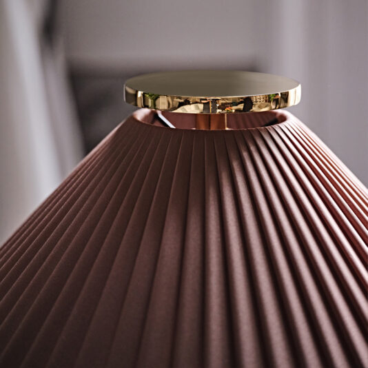 A close-up of the Classic Designer Luxury Table Lamp with a brown pleated shade and a gold-colored metallic top. The image focuses on the upper part of the lamp, highlighting the texture of the shade and the reflective surface of the metal.