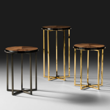 High End Walnut Veneered Side Table Three High End Walnut Veneered Side Tables are shown against a dark background. The modern round tables feature sleek metallic legs; two have gold finishes, and one has a dark finish. Their varying heights create a sophisticated tiered display.