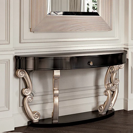 Designer High End Console The Designer High End Console, a luxurious black wooden table with ornate gold scrollwork legs, sits against a wall of intricate paneling. Above it hangs a large rectangular mirror with a geometric frame, creating an elegant and sophisticated setup.