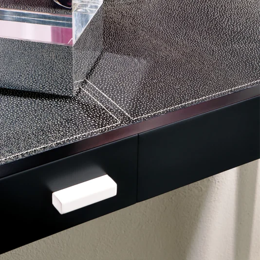 Modern Italian Leather Console The close-up of the black countertop with a textured finish showcases the Modern Italian Leather Console, featuring a reflective transparent rectangular box. Below it is a black drawer with a white handle, and the surface is dotted with white specks for an elegant touch.