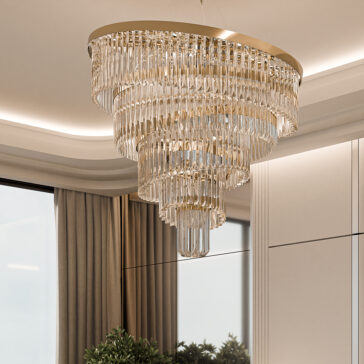 Gold Plated Spiral Crystal Designer Chandelier The Gold Plated Spiral Crystal Designer Chandelier, with cascading clear crystals and a tiered circular design, elegantly hangs from the ceiling. Large windows with curtains provide a glimpse of indoor plants in the background.