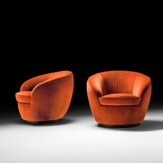 Two Luxury Designer Velvet Swivel Armchairs, featuring a modern orange hue, sleek curved design, and plush velvet upholstery, are displayed against a dark background. Each chair boasts a rounded backrest and seat, offering a stylish and comfortable seating option.