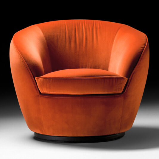 The Luxury Designer Velvet Swivel Armchair, upholstered in plush orange velvet, is displayed against a black background. It features a round, cushioned seat with a wide backrest and gently sloping sides, all supported by a circular black base. The soft and luxurious fabric gives the chair a contemporary and inviting appearance.