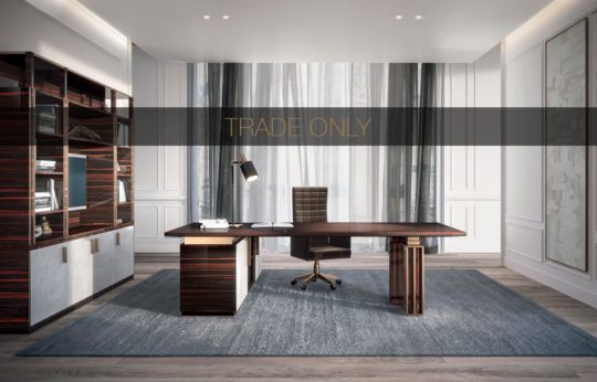 Modern office with a large wooden desk, leather office chair, and a bookshelf filled with books and decorative items. Grey rug on wooden floor, sheer curtains and a translucent banner across the image with the text "TRADE ONLY." Room has a minimalist design.