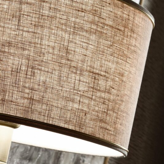 Italian Designer Gold Plated Table Lamp Here's a close-up of the beige-brown fabric lampshade with a textured finish, showcasing its intricate weave pattern. Mounted on the Italian Designer Gold Plated Table Lamp, the lampshade softly illuminates from the bulb inside, highlighting its texture and creating a warm ambiance.