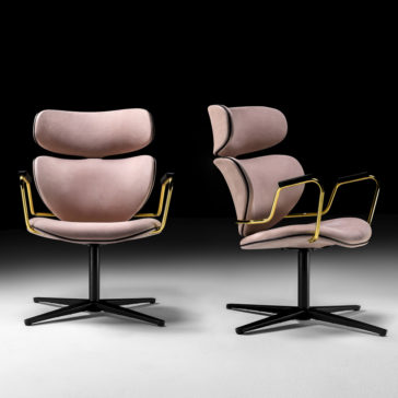 Two Designer Retro Leather Swivel Armchairs with pink cushioned seats and backs, gold metal armrests, and black metal bases are set against a dark background.