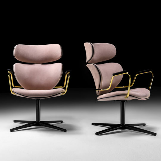 Two Designer Retro Leather Swivel Armchairs with pink cushioned seats and backs, gold metal armrests, and black metal bases are set against a dark background.
