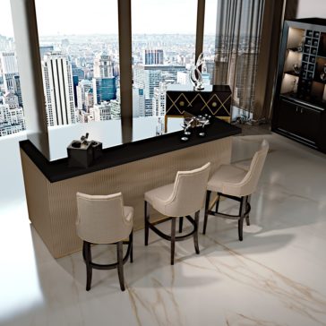 A modern, elegant bar setup with three high-backed beige chairs facing a sleek black countertop from the Luxury High End Italian Cocktail Bar collection. This sophisticated bar is placed in front of floor-to-ceiling windows offering a panoramic view of the city's skyline with tall buildings. The room is further enhanced by a marble floor.