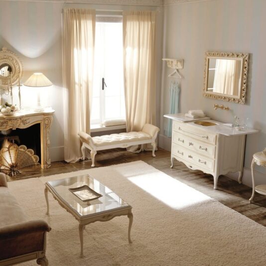 Designer Italian Bathroom Cabinet with Sliding Top An elegant, vintage-style living room with beige curtains letting in natural light. The room features classic furniture, including a fireplace, cushioned bench, coffee table, and dresser. A Designer Italian Bathroom Cabinet with Sliding Top adds unique charm to the soft, neutral tones creating a warm and inviting atmosphere.