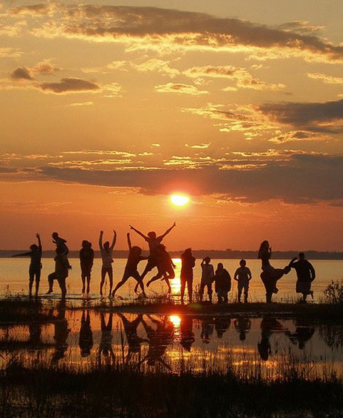party and dancing at the lake at sunset