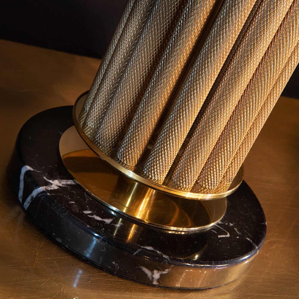 luxury furniture, detail of lamp base with textured, gold metallic poles and black marble base