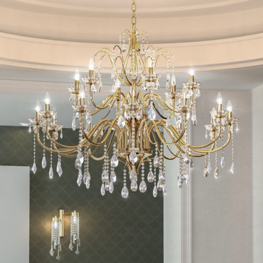 The Classic Cut Crystal Gold Plated Chandelier with multiple arms, candle-style lights, and hanging crystals hangs from a decorative ceiling, while two matching wall sconces appear in the background.