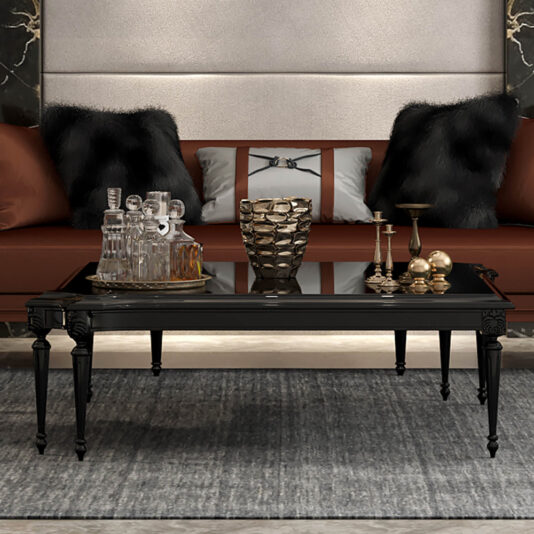 Louis Reproduction XVI Coffee Table A Louis Reproduction XVI Coffee Table sits on a gray rug in front of a brown sofa with black fur and silver pillows, decorated with glass decanters and gold candle holders, in a modern living room.