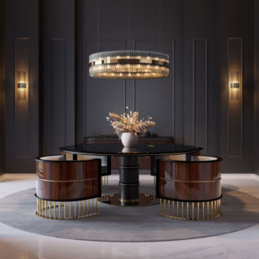 Contemporary Designer Tiered Chandelier A modern dining room showcases a round table with a dark polished surface and four matching chairs featuring wooden and gold finishes. Overhead, the striking Contemporary Designer Tiered Chandelier adds elegance. A dried flower centerpiece graces the table, while wall lights brighten the dark walls.