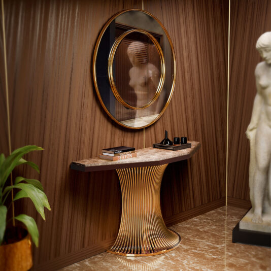 Marble Demi Console A modern entryway features a round mirror above a Marble Demi Console, with a plant on the left and a white statue on the right, set against wood-paneled walls and a marble floor.