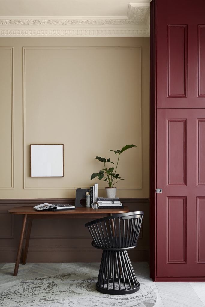 desk space with warm neutral walls and shutters in deep red