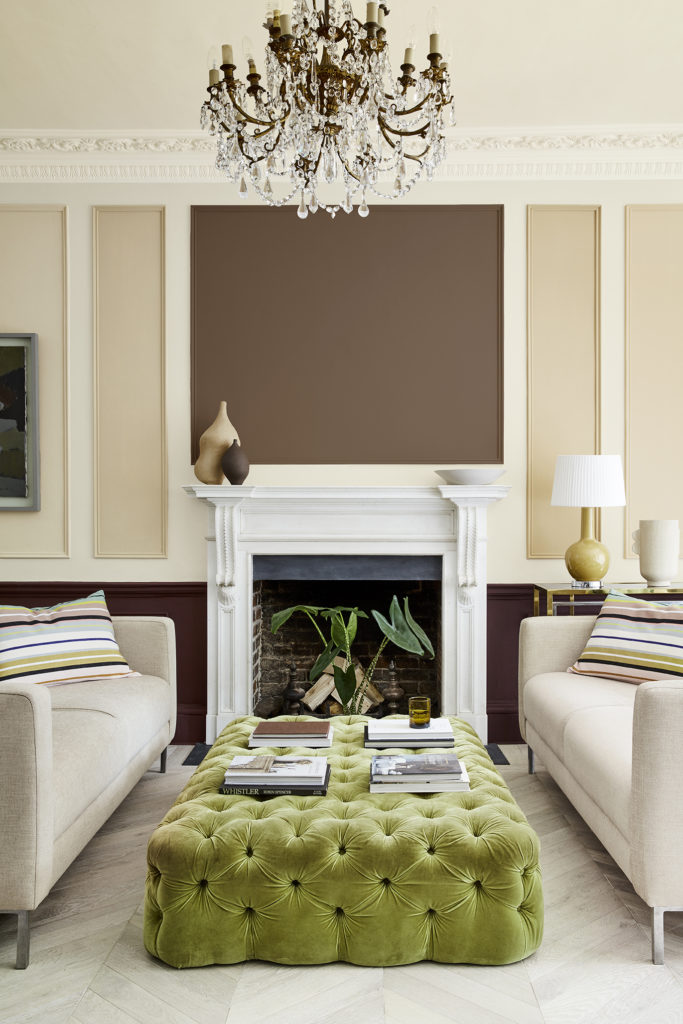 a calm colour scheme with neutral walls and sofas and an accent of lime green footstool
