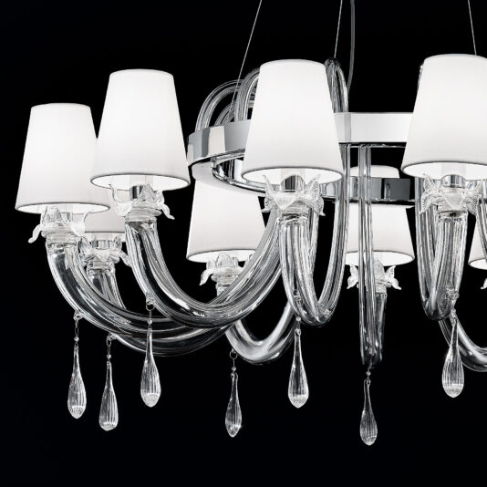 Clear Murano Glass Chandelier With Silk Shades Introducing the Clear Murano Glass Chandelier With Silk Shades: a contemporary chandelier boasting silk lampshades on each light. This sophisticated fixture features graceful, curved clear Murano glass arms adorned with teardrop-shaped crystal accents dangling below each arm, all set against a sleek black background.
