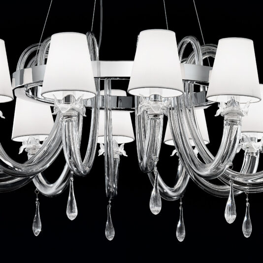 Clear Murano Glass Chandelier With Silk Shades The Clear Murano Glass Chandelier With Silk Shades features a collection of glossy, transparent curved arms made from clear Murano glass. Each arm holds a white silk lampshade and is adorned with teardrop-shaped crystal pendants at the ends. Set against a black background, the chandelier's modern and elegant design is strikingly prominent.