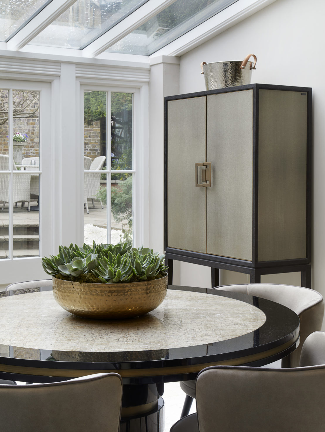 Luxury kitchen table and chairs with decorative bowl full ofd succulents.