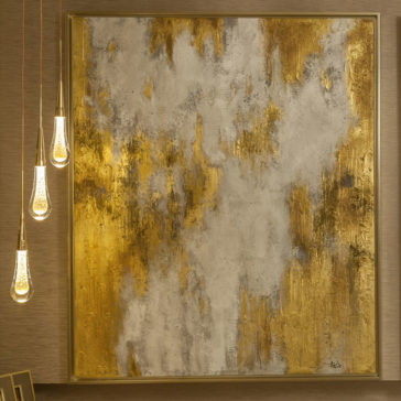 Set of 3 Glass Drop Pendant Lights A large abstract painting is mounted on the wall, showcasing textured swirls and patches in golden yellow, white, and gray. The Set of 3 Glass Drop Pendant Lights with exposed bulbs and a minimalistic design casts a warm glow that beautifully illuminates the artwork.