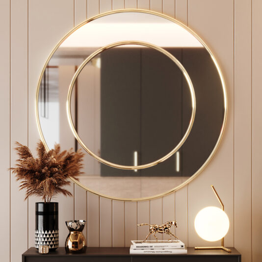 Contemporary Round Wall Mirror A Contemporary Round Wall Mirror with a smaller concentric circle mirror hangs on a beige-paneled wall. Below, a black cabinet showcases a black and white vase with dried plants, a small sculpture of a horse, and a minimalistic lamp with a spherical light.