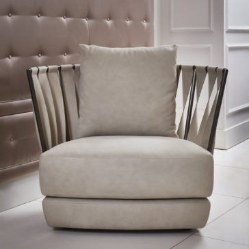 Luxury Modern Leather Twist Armchair The Luxury Modern Leather Twist Armchair, featuring a light gray leather finish, a plush square cushion, and unique artistic black metal armrests that resemble ribbons, is set on a white tiled floor against a backdrop of a button-tufted beige wall and a white paneled wall.