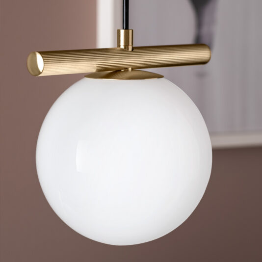 Modern Murano Glass Pendant Light Cluster The Modern Murano Glass Pendant Light Cluster showcases a sophisticated design with a white spherical glass shade, complemented by a brass horizontal rod and accents, and is suspended from a black cord. The elegant setting includes a muted pink wall adorned with framed blurred artwork, further enhancing the stylish ambiance of this pendant light cluster.