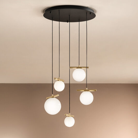 The Contemporary Murano Glass Pendant Light Chandelier, featuring a sleek black circular ceiling mount, showcases five white spherical lights suspended at varying heights by slender black cords. Each light is enhanced with a brass accent, beautifully contrasting against the beige wall and ceiling.