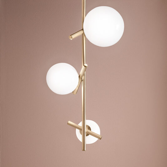 Contemporary Murano Glass Vertical Pendant Light Introducing the Contemporary Murano Glass Vertical Pendant Light, a stylish fixture with a gold rod adorned by three white, spherical glass lamps arranged at different angles. Set against a muted mauve-colored wall, this light accentuates modern elegance.