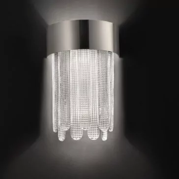 Contemporary Venetian Glass Wall Light The Contemporary Venetian Glass Wall Light features a modern wall sconce design, characterized by a sleek, cylindrical stainless steel top complemented by cascading crystal strands. It emits a soft, warm glow against a dark background.
