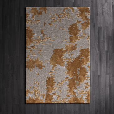 High Quality Abstract Hand Woven Rug A High Quality Abstract Hand Woven Rug, featuring an abstract pattern in shades of brown and gray and laid on a dark wooden floor, showcases irregular patches that blend the two colors to create a textured appearance.