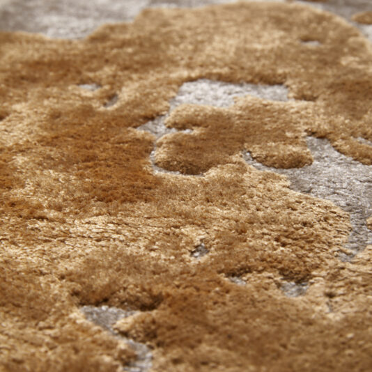 Close-up of a High Quality Abstract Hand Woven Rug featuring luxurious, high-quality craftsmanship. The rug showcases a mix of beige, brown, and gray tones with a plush, slightly irregular pattern that gives it a rich and cozy appearance, reminiscent of natural landscapes or abstract art.