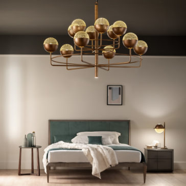 Large Modern Round Pendant Chandelier A modern bedroom showcases a bed with a green and white headboard, complemented by a cozy beige blanket. Beside it, there is a matching side table adorned with a lamp and decor items. From the ceiling hangs the Large Modern Round Pendant Chandelier, featuring numerous bulbs that illuminate the room brilliantly. The walls are decorated with minimalist artwork to complete the contemporary look.