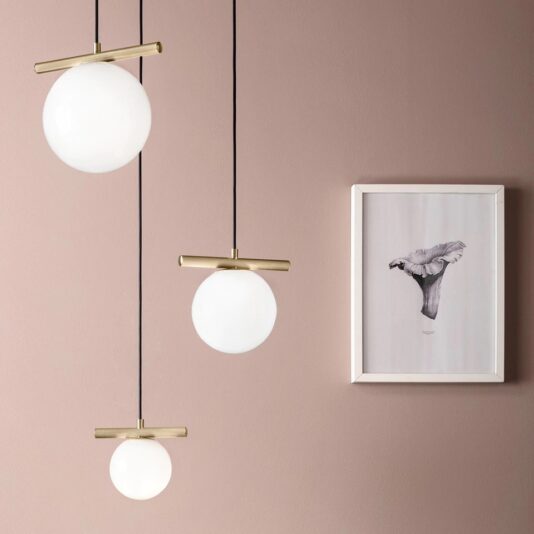 Modern Murano Glass Pendant Light Cluster A minimalist interior is adorned by the Modern Murano Glass Pendant Light Cluster, which features glowing glass pendants with brass fixtures hanging at varying lengths against a muted pink wall. To the right, a framed sketch of a bird perched on a branch completes the look.