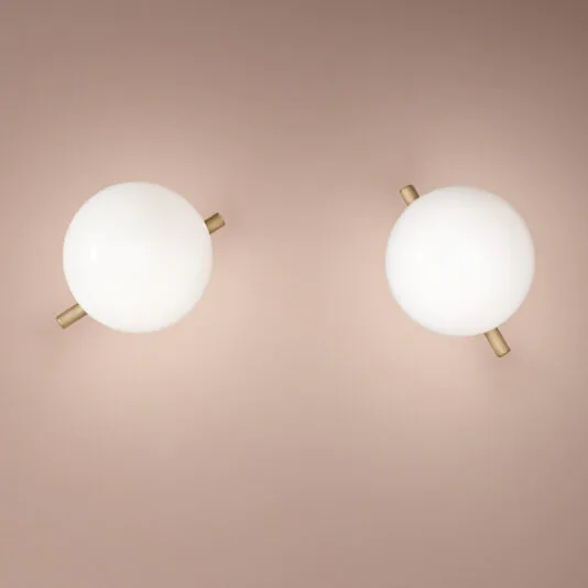 Modern Murano Glass Wall Light Two Modern Murano Glass Wall Lights with frosted covers are mounted on a neutral-toned wall. These minimalist lights feature brass or gold-tone horizontal rods that intersect the white orb lights, adding a sophisticated touch to any room.