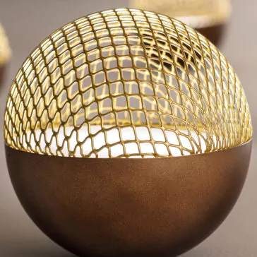 The Modern Round Pendant Chandelier boasts a textured metallic bottom and a gold wire mesh top that forms a dome over its smooth white interior. This brown spherical chandelier features an intricate geometric pattern on the wire mesh, with several similar chandeliers blurred in the background.