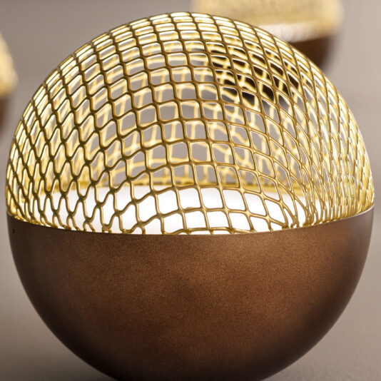 Modern Round Pendant Chandelier The Modern Round Pendant Chandelier boasts a textured metallic bottom and a gold wire mesh top that forms a dome over its smooth white interior. This brown spherical chandelier features an intricate geometric pattern on the wire mesh, with several similar chandeliers blurred in the background.