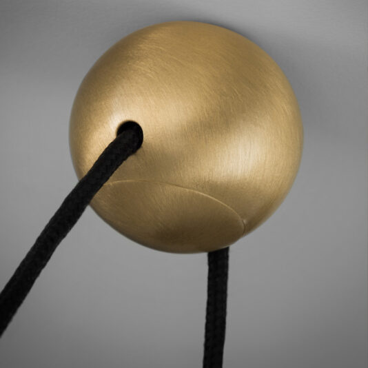 A detailed close-up depicts the Contemporary Black LED Pendant Light Cluster, featuring a round, matte gold fixture through which a thick, black cord is elegantly threaded. The scene is set against a smooth, light gray background.