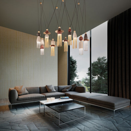Contemporary Brown LED Pendant Light Cluster A modern living room featuring a large sectional sofa with gray upholstery and brown cushions. A low, rectangular coffee table with a glass top sits in front of the sofa. Large windows on the right let in natural light, while a Contemporary Brown LED Pendant Light Cluster hangs from the ceiling.