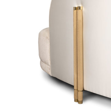 Close-up view of a white upholstered furniture piece, showcasing a textured brass metal accent. The brass detail runs vertically along the edge, adding a touch of elegance and sophistication to the design, reminiscent of the Contemporary Curved Velvet Sofa.