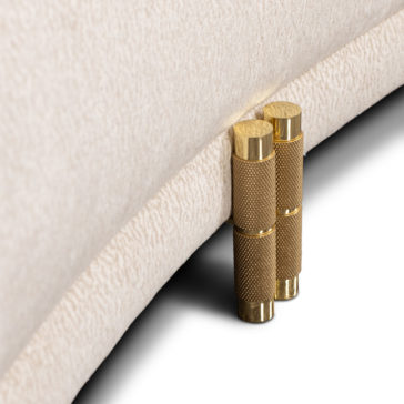 Close-up of two cylindrical, gold-textured metal legs supporting the 