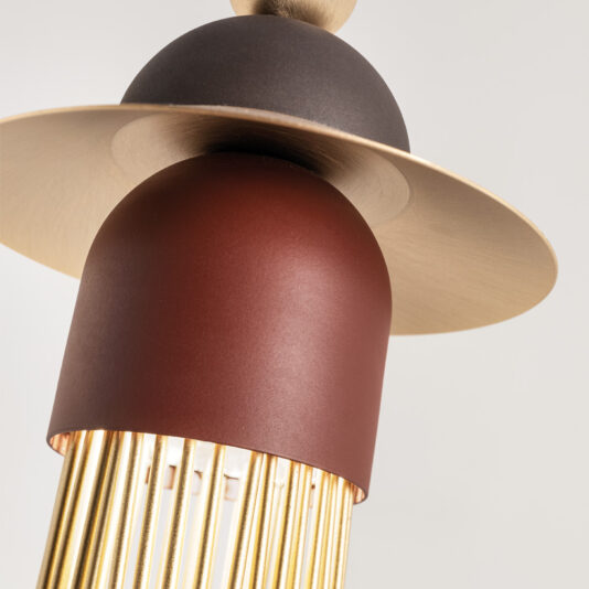 Contemporary Triple LED Pendant Light A detailed close-up of the Contemporary Triple LED Pendant Light showcases its brown and gold cylindrical body, complemented by thin vertical golden rods extending from the bottom. The fixture is elegantly accented by a flat disk, reminiscent of a hat brim, positioned above the cylinder. The background is plain white.